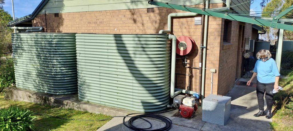 Margaret Gough next to her water tanks