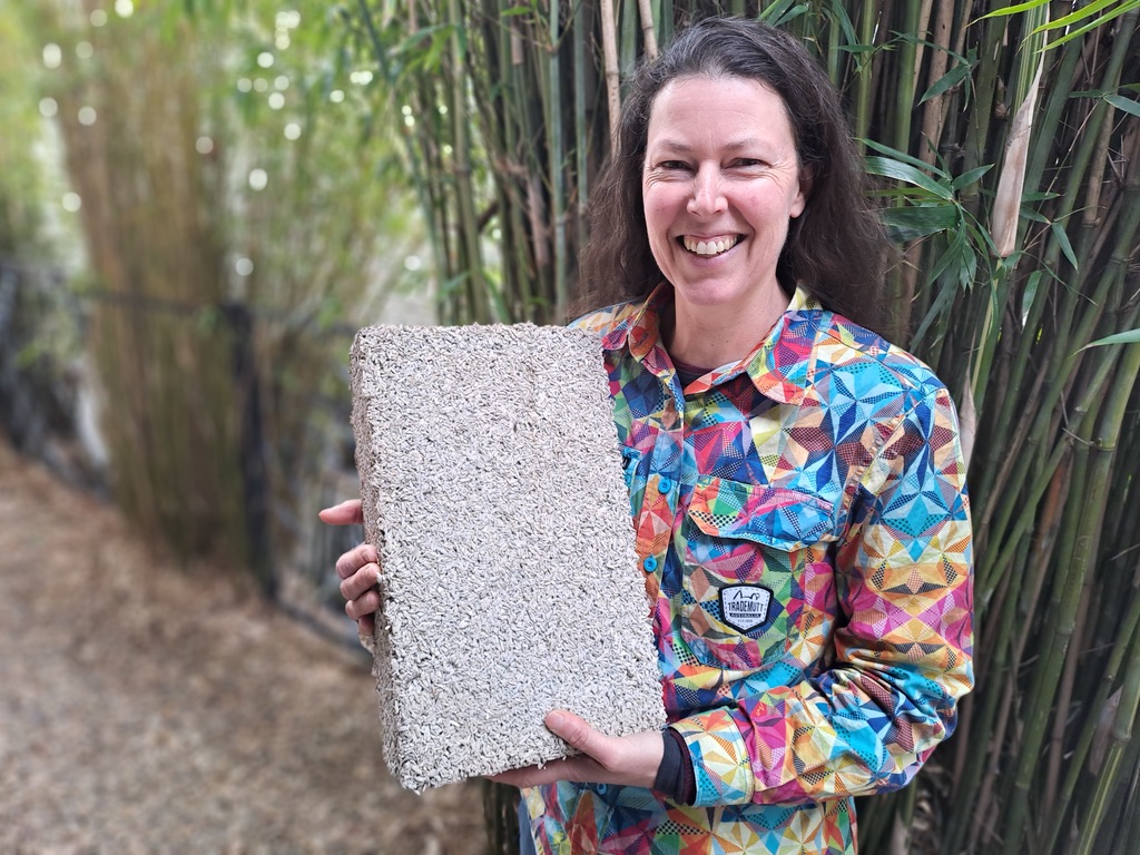 Kirstie Wulf of Shelter Building Design holding a hempcrete block