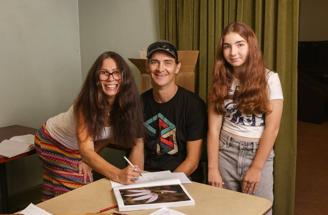 Sabine Hanisch, Ben Jasiak and their daughter Arabella signing books at All About Orchids