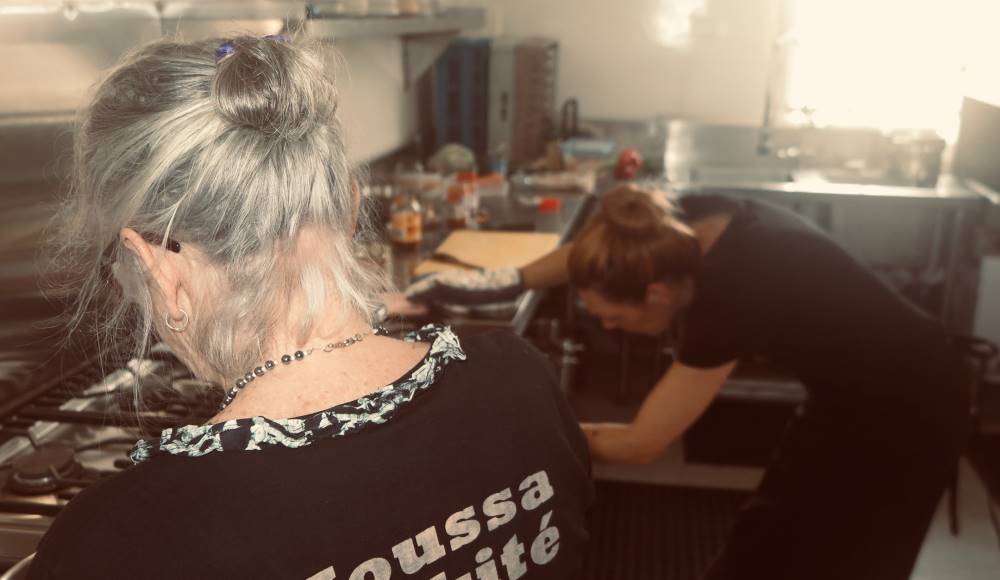 A class participant and Teya Brooks Pribac get creative in the kitchen.
