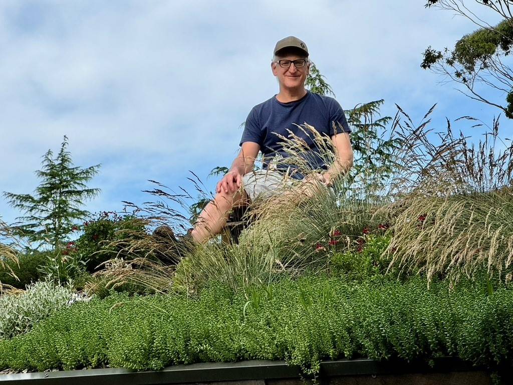 Mark Liebman sitting on his green roof.